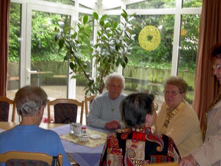 Seniorinnen unterhalten sich am Tisch im Aufenthaltsbereich