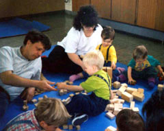 Betreuer und Kinder spielen auf dem Boden