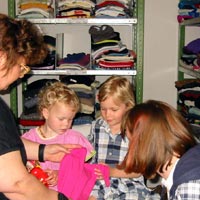 Kinder bei der Anprobe in der Kleiderkammer