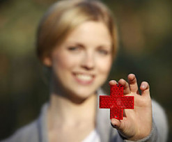 Frau zeigt rotes Kreuz