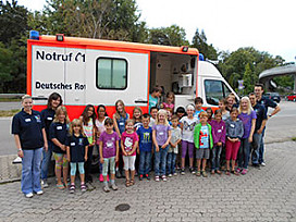Gruppenbild Kinder und Betreuer vor einem Rettungswagen