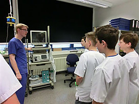 Arzt erklärt Jungen eine Maschine in einem Krankenhaus