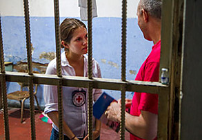 Mitarbeiterin des Humanitären Völkerrechts im Gespräch mit einem Häftling