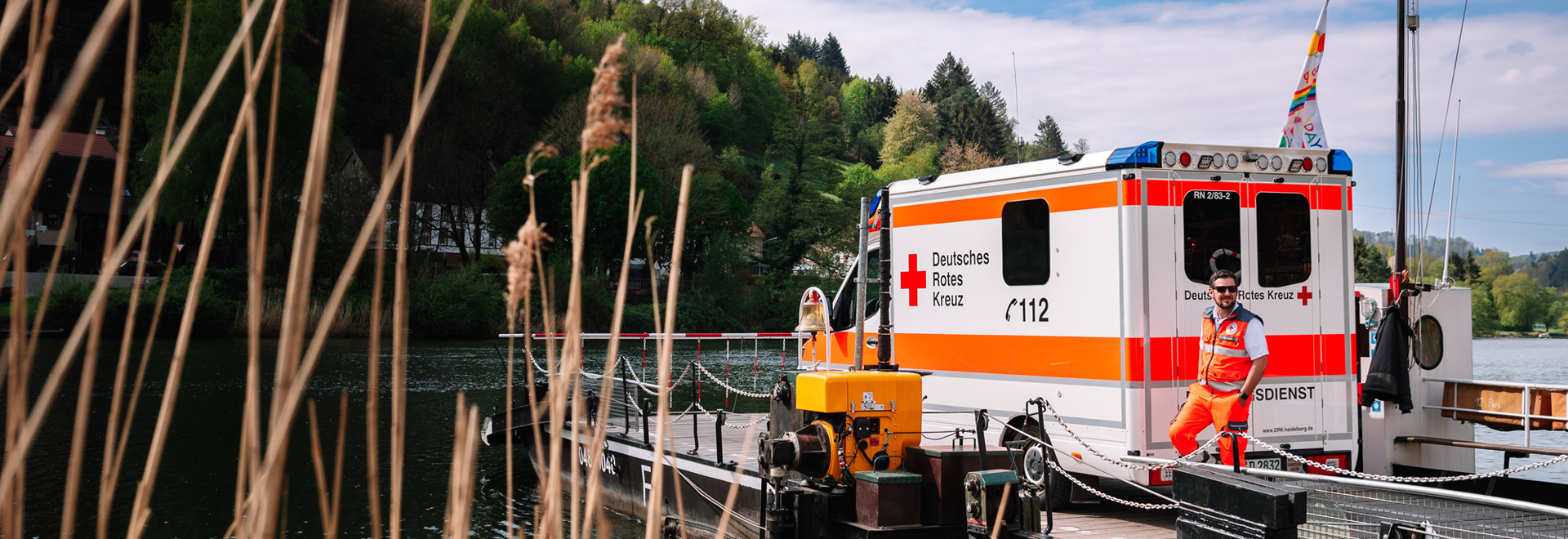 Rettungssanitäter neben einem Rettungswagen am Neckar-Ufer
