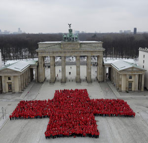 Rotes Kreuz aus Menschen vor dem Brandenburger Tor in Berlin
