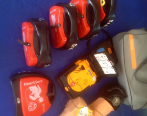 6 Defibrillatoren in Plastik-Koffern mit der Aufschrift HeartSave