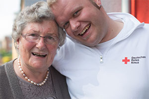 Pfleger umarmt eine Seniorin