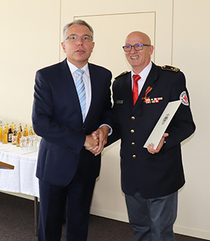 Jürgen Wiesbeck (r.) erhält das Bundesverdienstkreuz von Landrat Stefan Dallinger im Landratsamt Rhein-Neckar-Kreis.