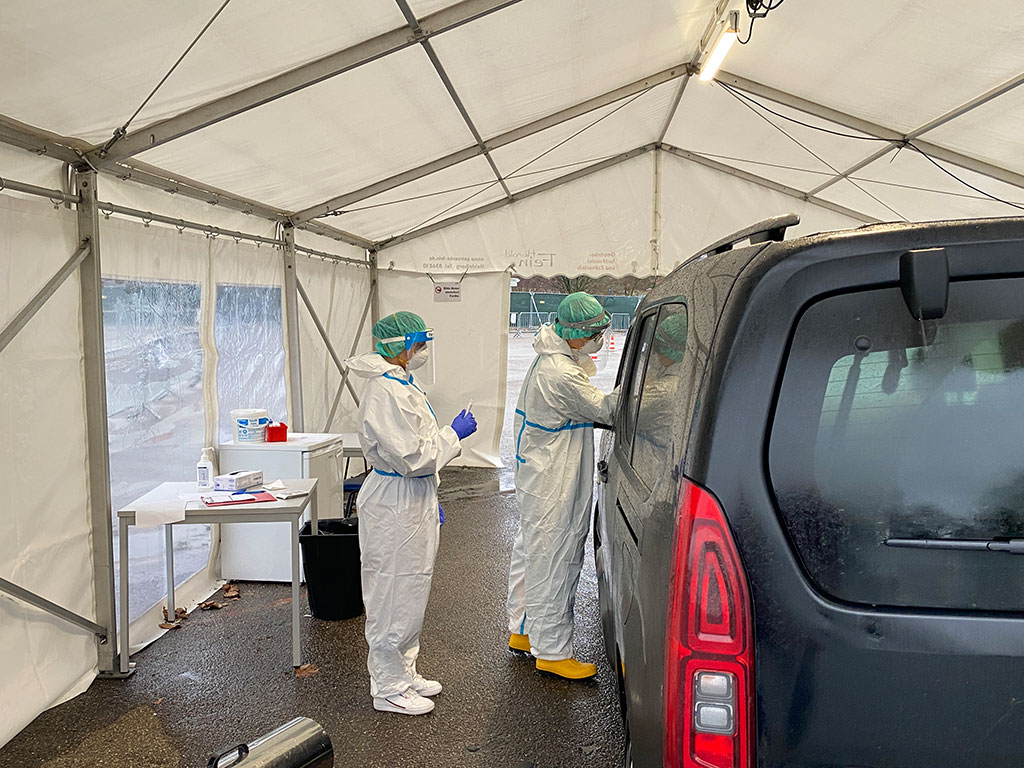 DRK-Mitarbeiter mit Schutzkleidung macht einen Corona Schnelltest in der Drive-In Teststation