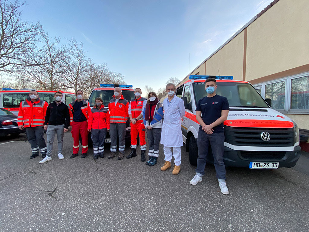 Gruppenbild des Mobilen Impfteams vor DRK-Fahrzeugen