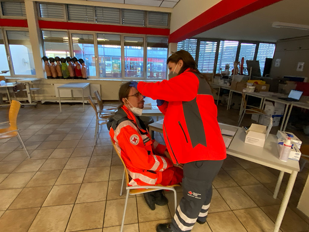 DRK-Mitarbeiterin macht einen Corona-Schnelltest bei einem Kollegen