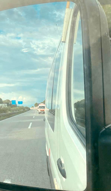 DRK-Fahrzeugkolonne durch einen Rückspiegel betrachtet