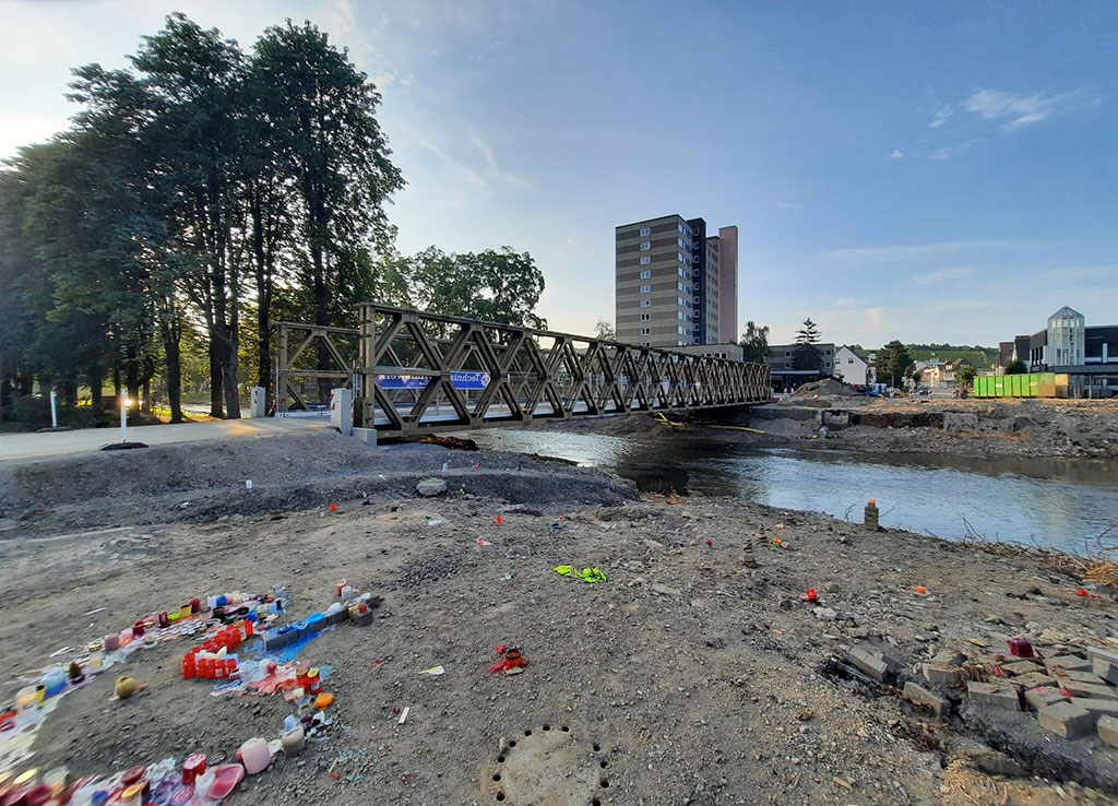 Kerzen zu einem Herz angeordnet auf Sandboden