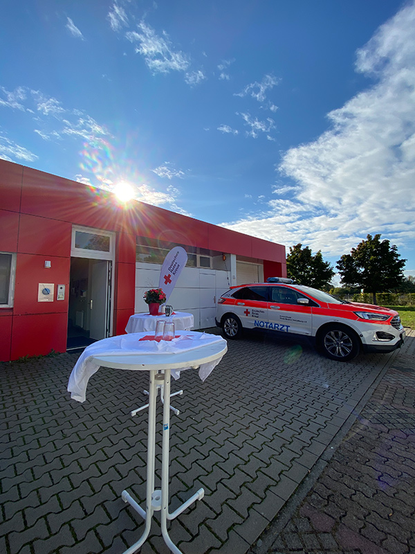 Stehtisch vor der Wache, Notarztwagen im Hintergrund