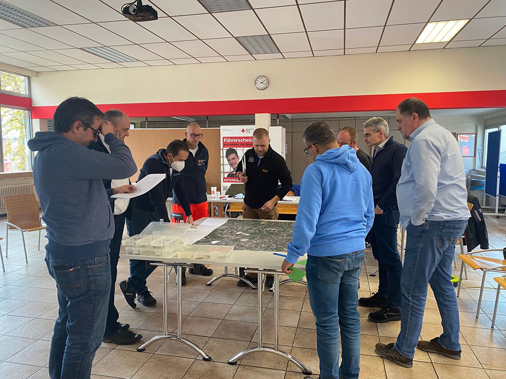 Teilnehmer besprechen Fallbeispiele an einem Lageplan