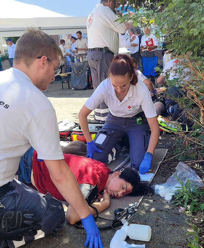 Zwei Sanitäter*innen versorgen eine verletzte Person am Unfallort