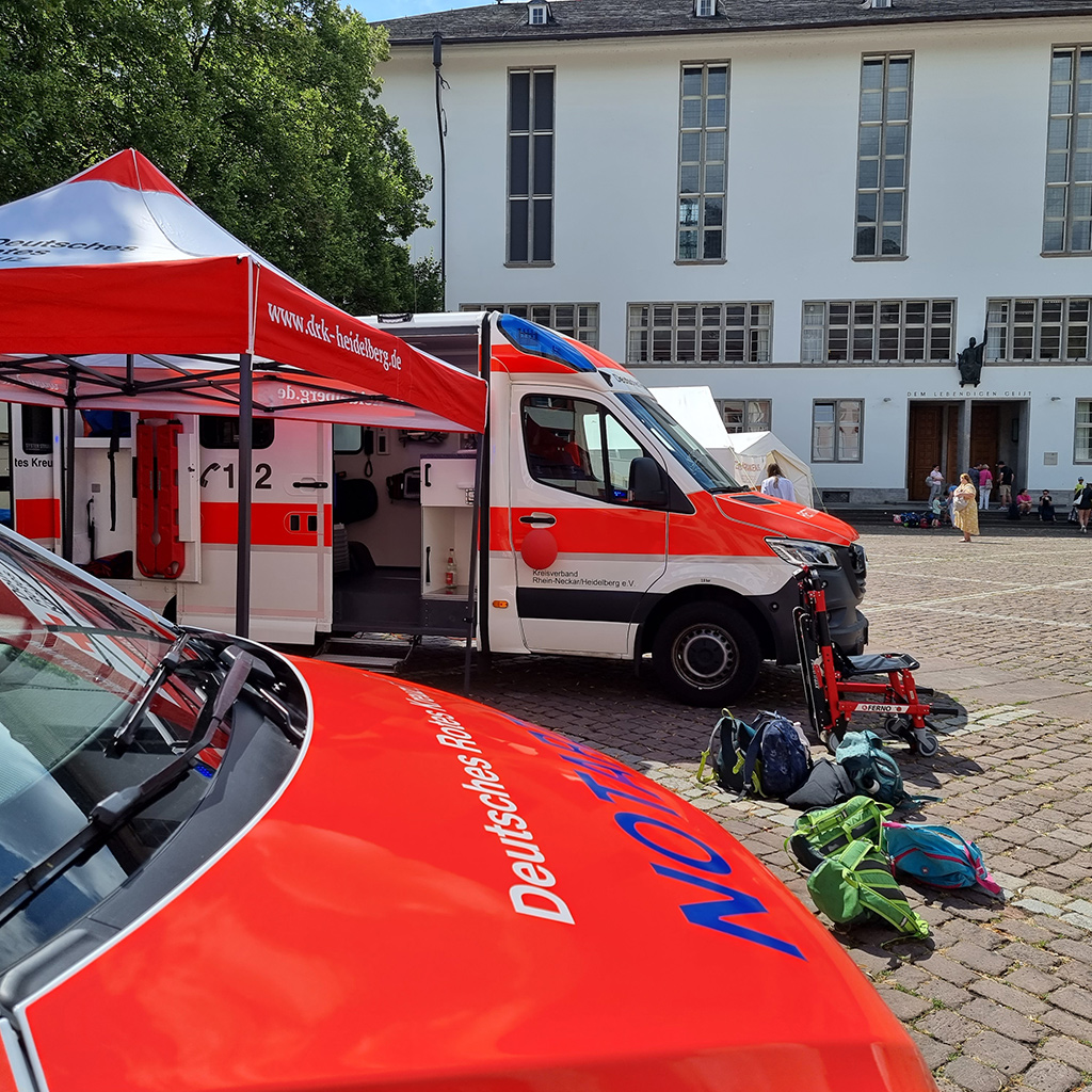 Zwei Rettungsfahrzeuge und ein aufgespannter DRK-Sonnenschirm