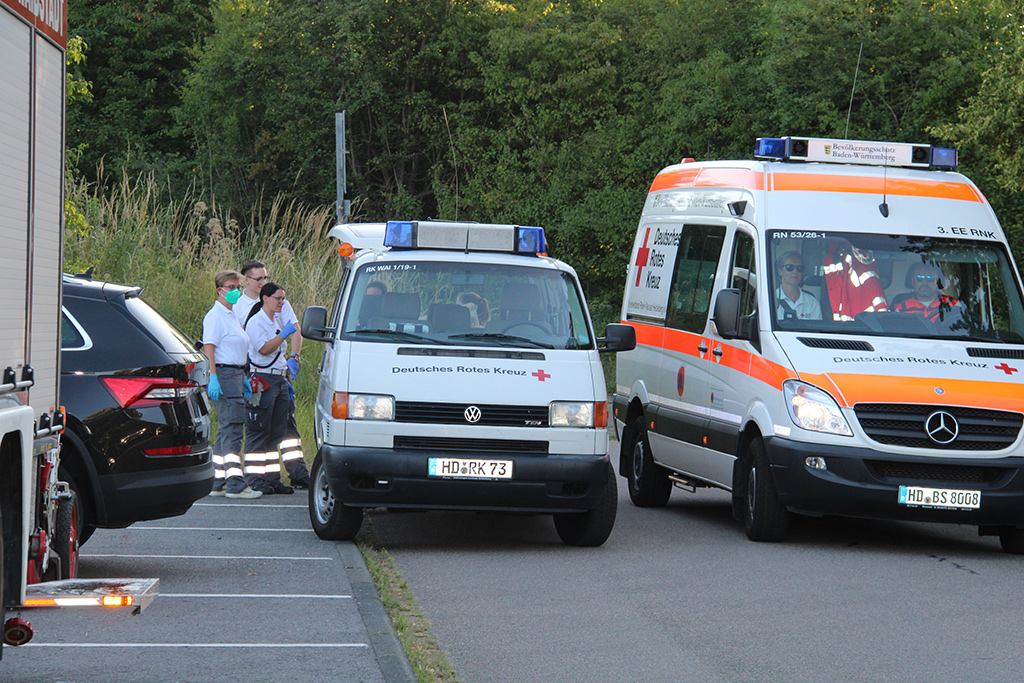 DRK-Personal  neben zwei Rettungsfahrzeugen