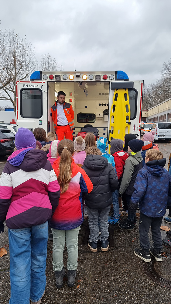 Die Schulkinder begutachten einen Rettungswagen