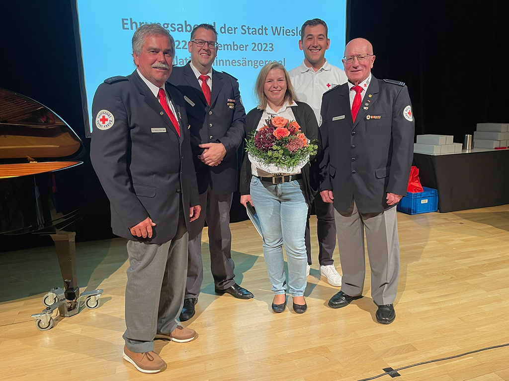 Gruppenbild mit der geehrten Katrin Ziefle, die einen Blumenstrauß in der Hand hält