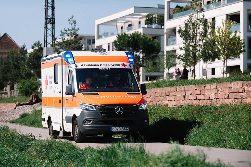 Rettungswagen des DRK Heidelberg fährt entlang eines Wohngebietes
