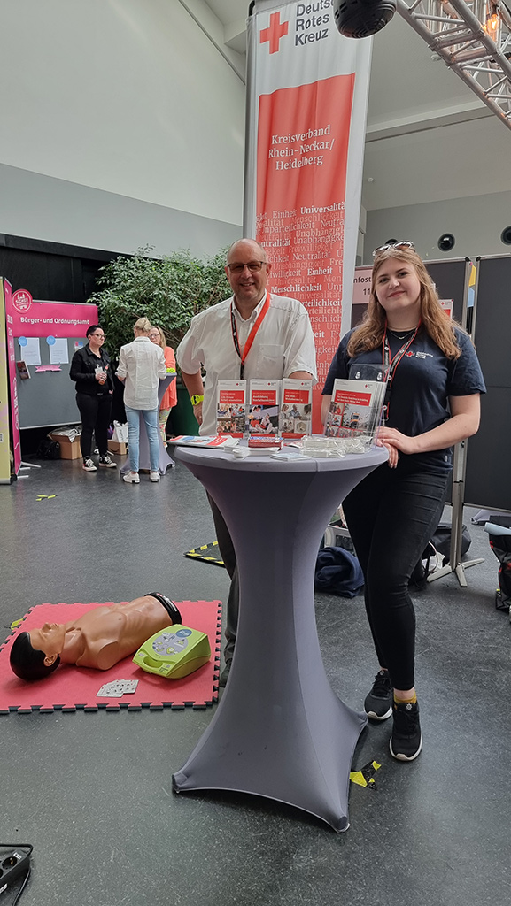 Andreas Fetzner mit Melina Götzelmann am DRK-Stand im Innenbereich.