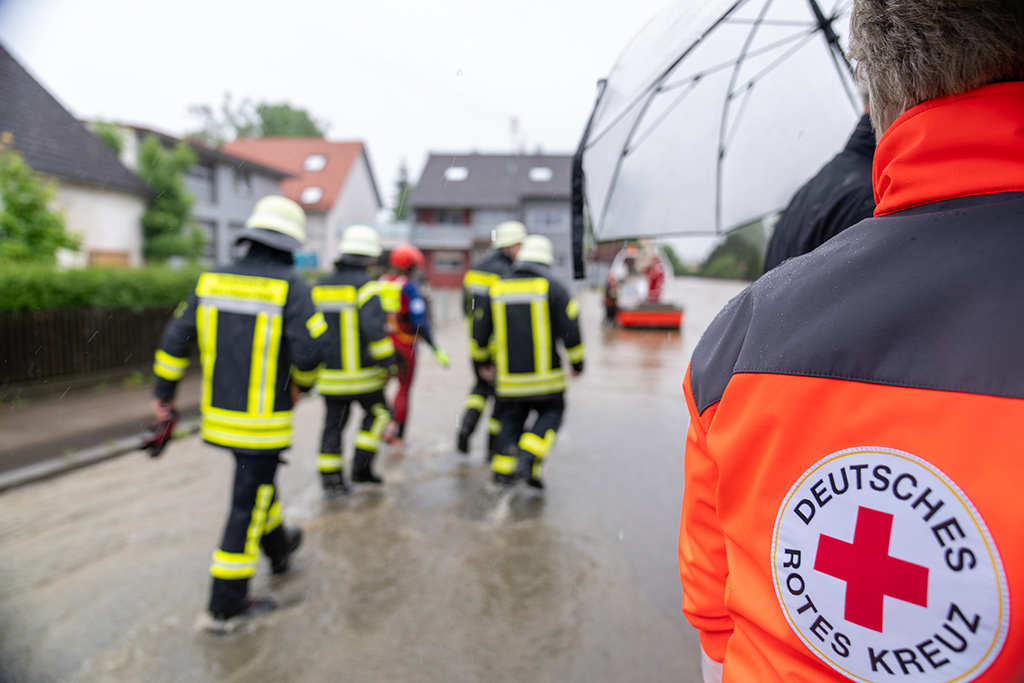 Bild größer ansehen Einsatzkräfte von Feuerwehr und DRK auf überschwemmter Straße