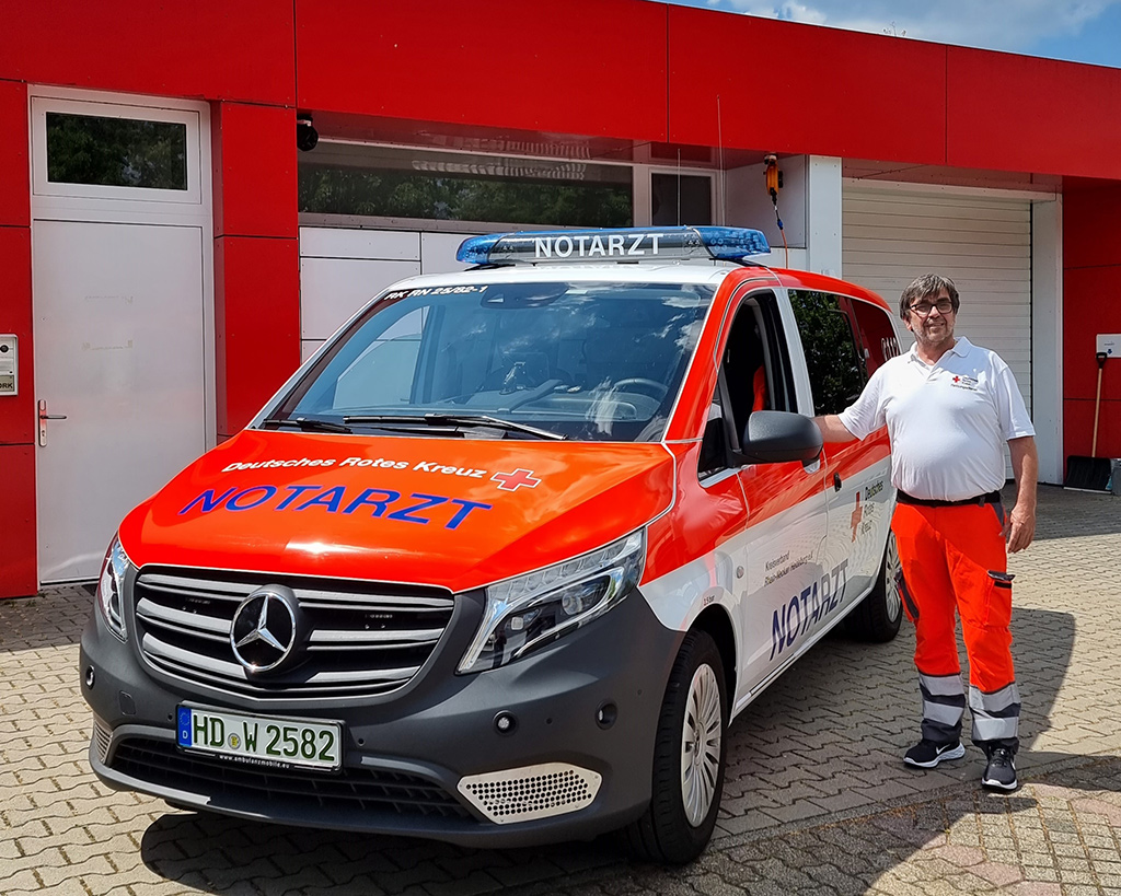 Hugo Groß neben einem Notarzt-Fahrzeug