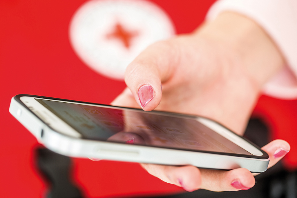 Frauenhand hält ein Smartphone; Foto: A. Zelck / DRK