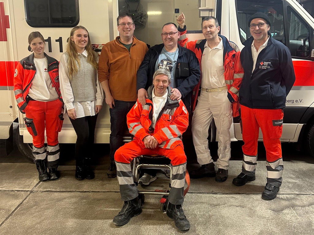 Gruppenbild: Hans-Jürgen Brandner mit Kolleginnen und Kollegen vor einem Rettungswagen