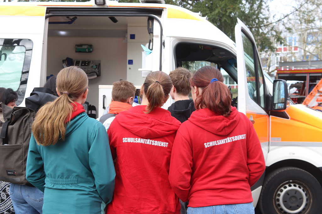 Jugendliche betrachten einen Rettungswagen