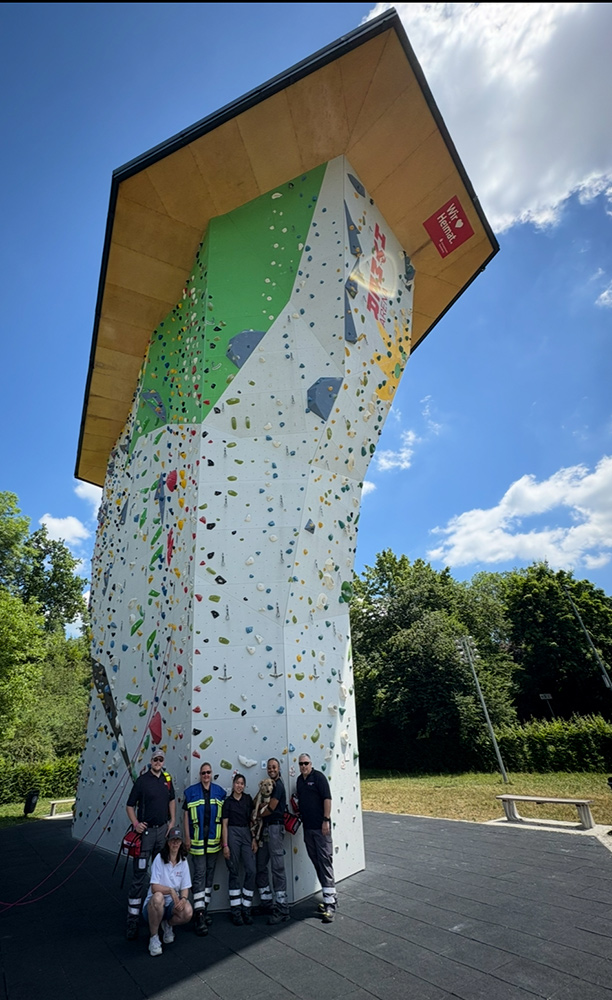 Teilnehmende des DRK Rhein-Neckar Heidelberg stehen vor einer großen Kletterwand