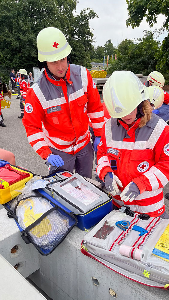Zwei Sanitäter nehmen Verbandsmaterial aus Erste-Hilfe-Koffern