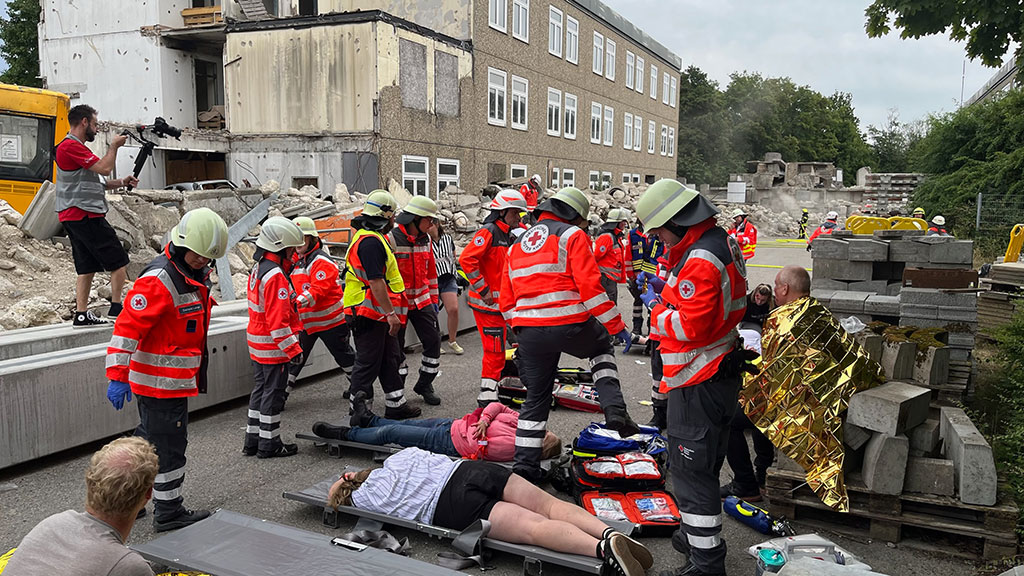 Viele Sanitäter versorgen Verletzte, die auf Tragen auf dem Boden liegen