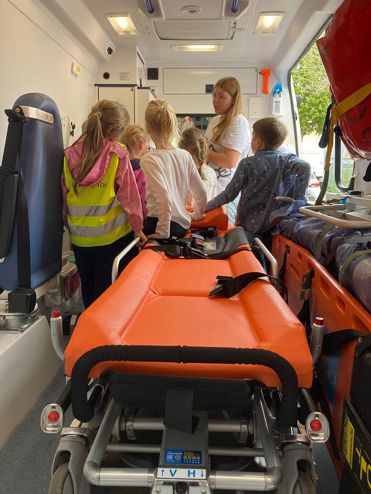 Eine Betreuerin mit den Kindern im Rettungswagen