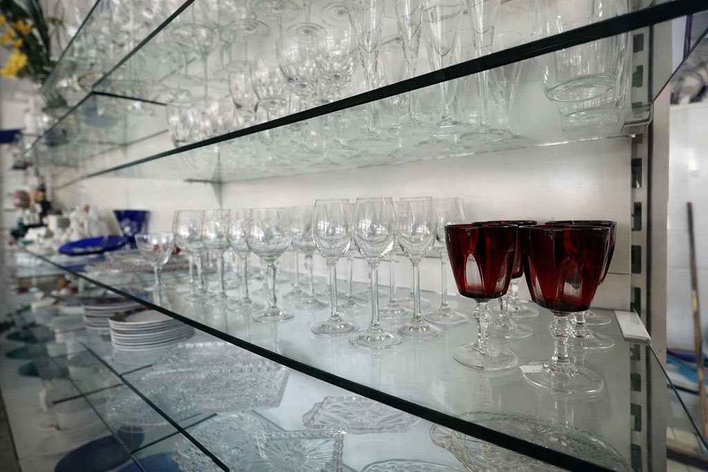 Weingläser und anderes Geschirr in einem Regal mit Glasböden