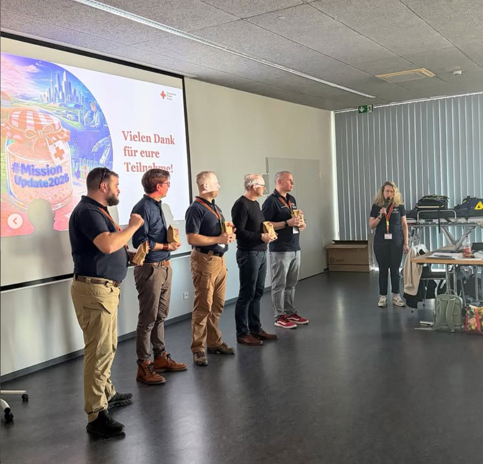 Verschiedene Menschen vor einem großen Display bei einem Vortrag