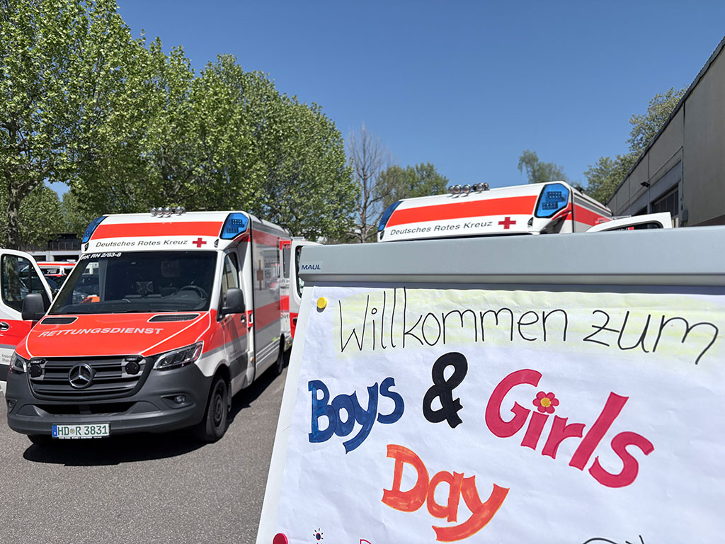 Notarztwagen auf dem Parkplatz, daneben ein Schild mit der Aufschrift Willkommen zum Boys & Girls Day