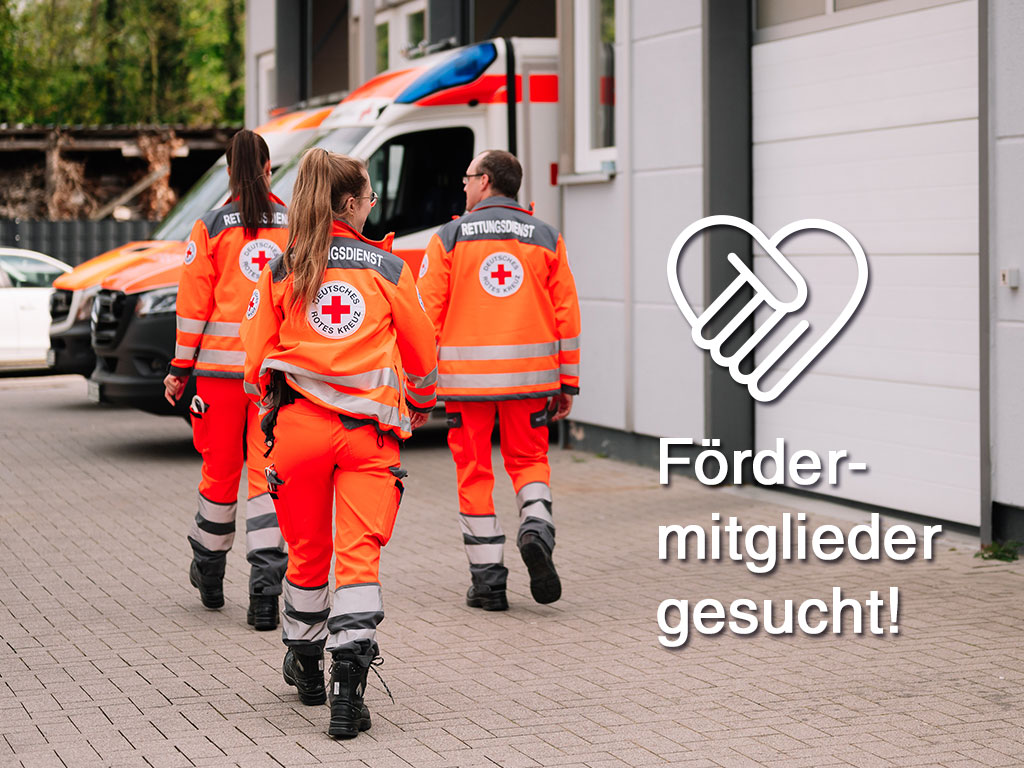 Drei DRK-Mitarbeiter laufen zum Rettungswagen, daneben steht Fördermitglieder gesucht!