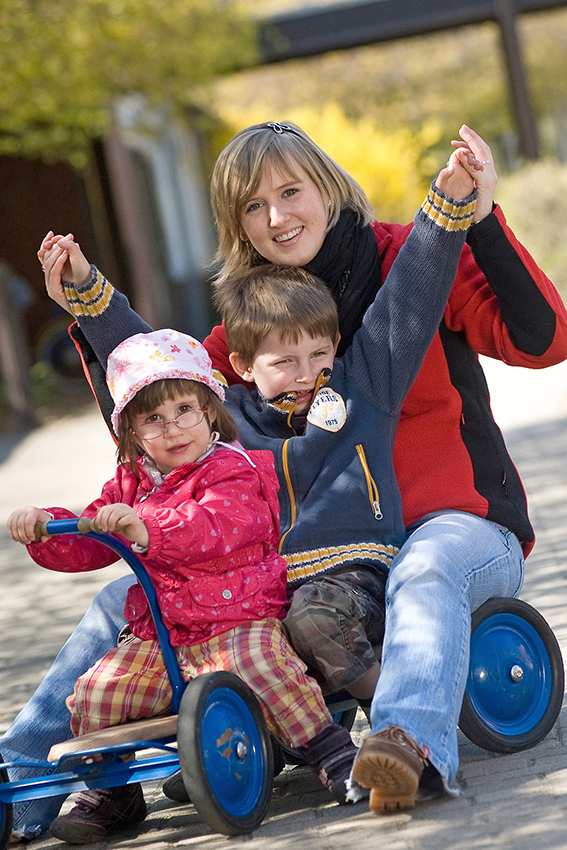 Mutter mit zwei Kindern auf einem Spielgefährt; Foto: M. Eram