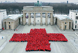 Rotes Kreuz aus Menschen vor dem Brandenburger Tor