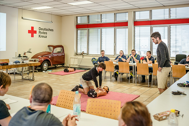 Jemand zeigt an einem Torso Herzmassage