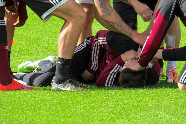 Verletzter Fußballspieler liegt auf dem Rasen