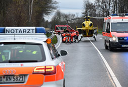 Rettung mit Rettungsfahrzeugen und Hubschrauber auf einer Straße