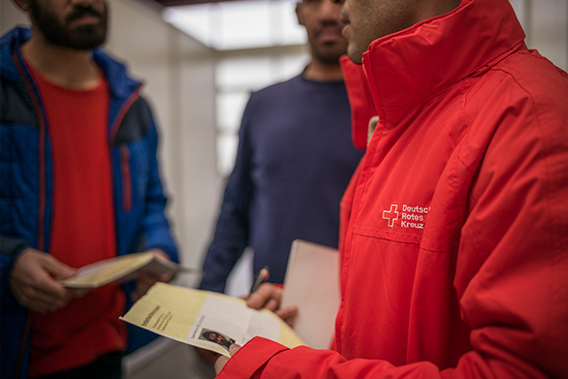 Migranten in einer Halle