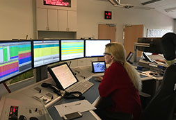 DRK-Mitarbeiterin beobachtet mehrere Monitore in der Leitstelle