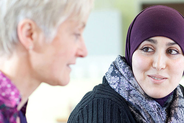 Zu den Informationen über die Projekte mit Geflüchteten Frau mit Kopftuch spicht mit einer anderen Frau