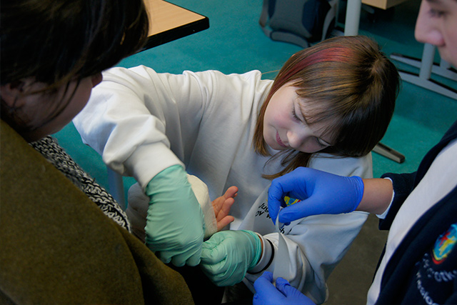 Kind legt einem anderen Kind einen Verband an