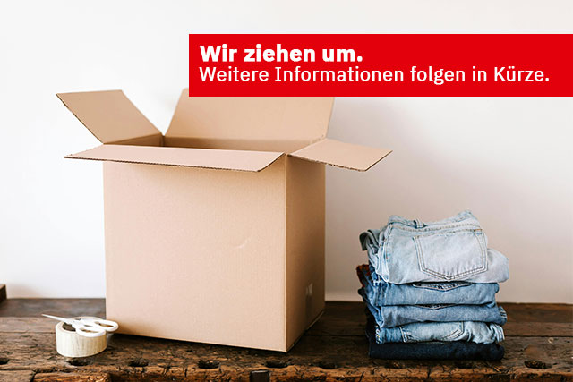 Umzugskarton, daneben Jeans und der Text Wir ziehen um. Weitere Informationen folgen in Kürze.